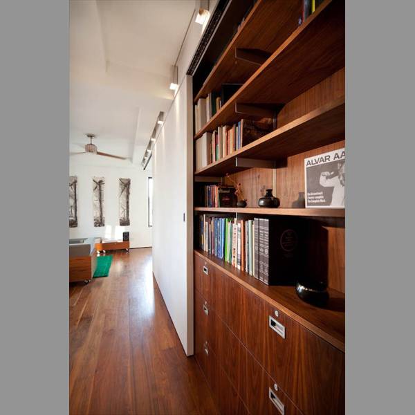 the sliding wall conceals the library shelves, cabinets and storage